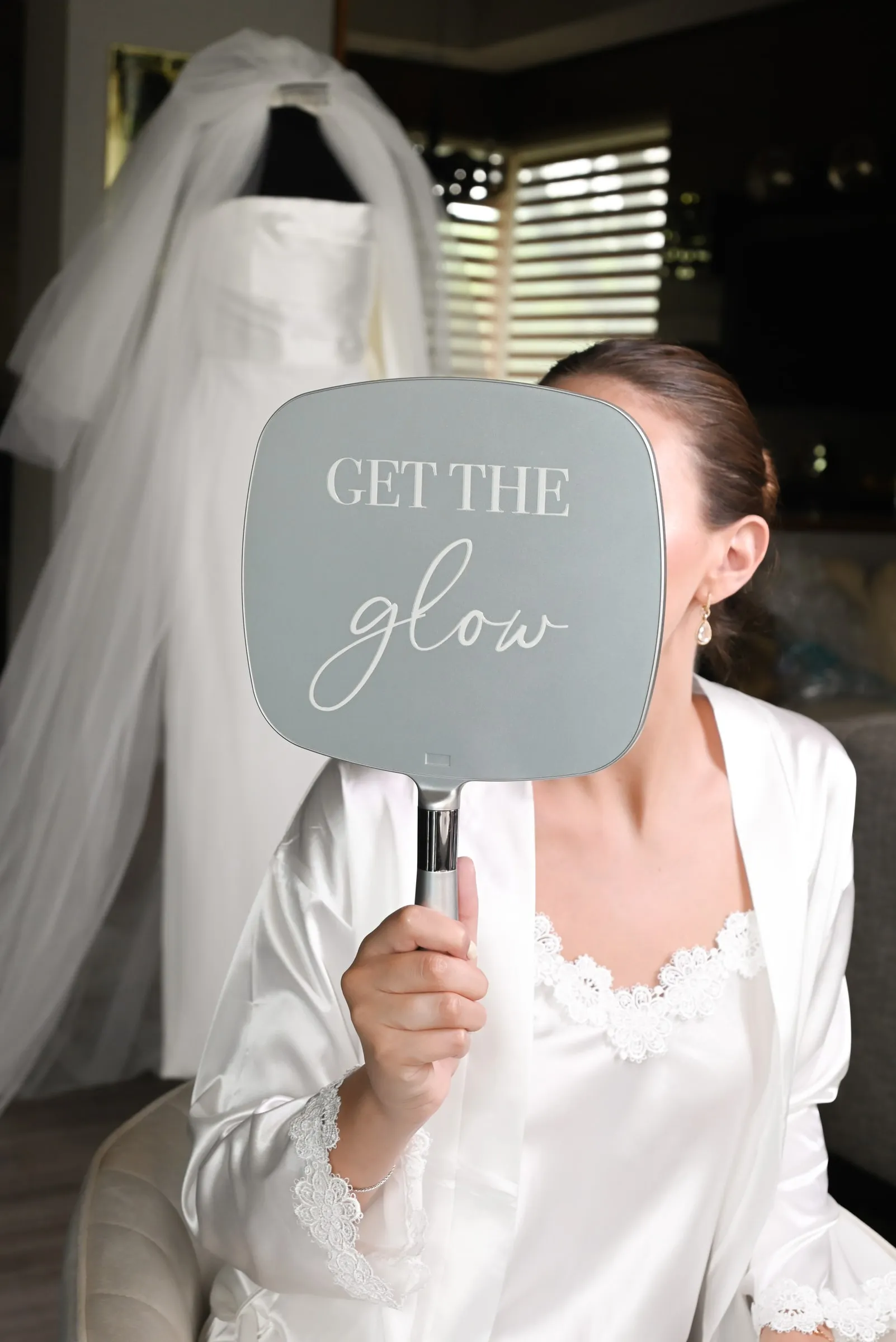 Novia sosteniendo el espejo de mano de Get The Glow